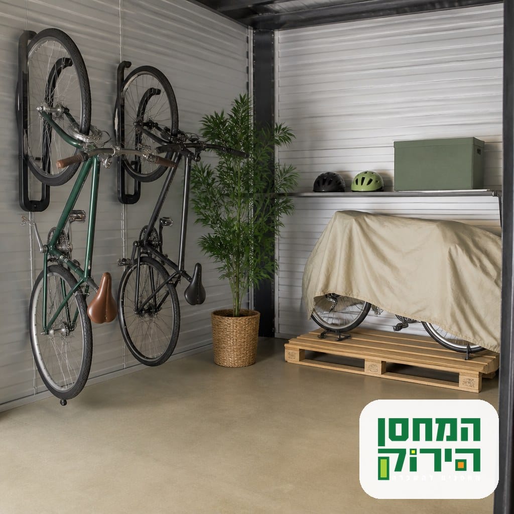 אחסון אופניים ביחידת אחסון נקייה, שני זוגות תלויים על ווים בקיר ואחד עומד על משטח עץ מתחת לכיסוי בד