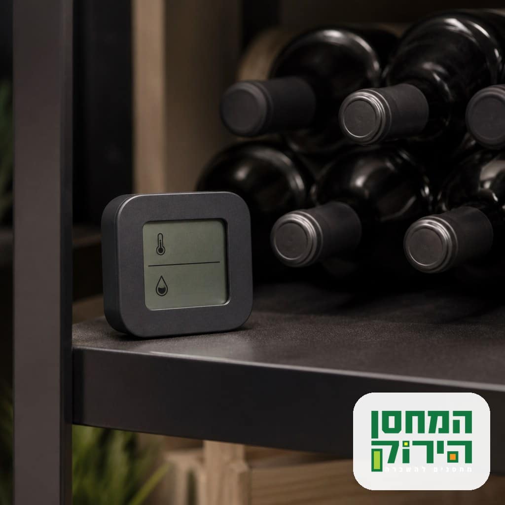 מד טמפרטורה ולחות דיגיטלי על מדף לצד בקבוקי יין מאוחסנים במחסן